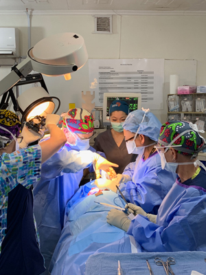 NU student in operating room in Kenya with surgeons. View 1