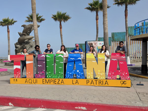 NU students behind Tijuana sign. View 1